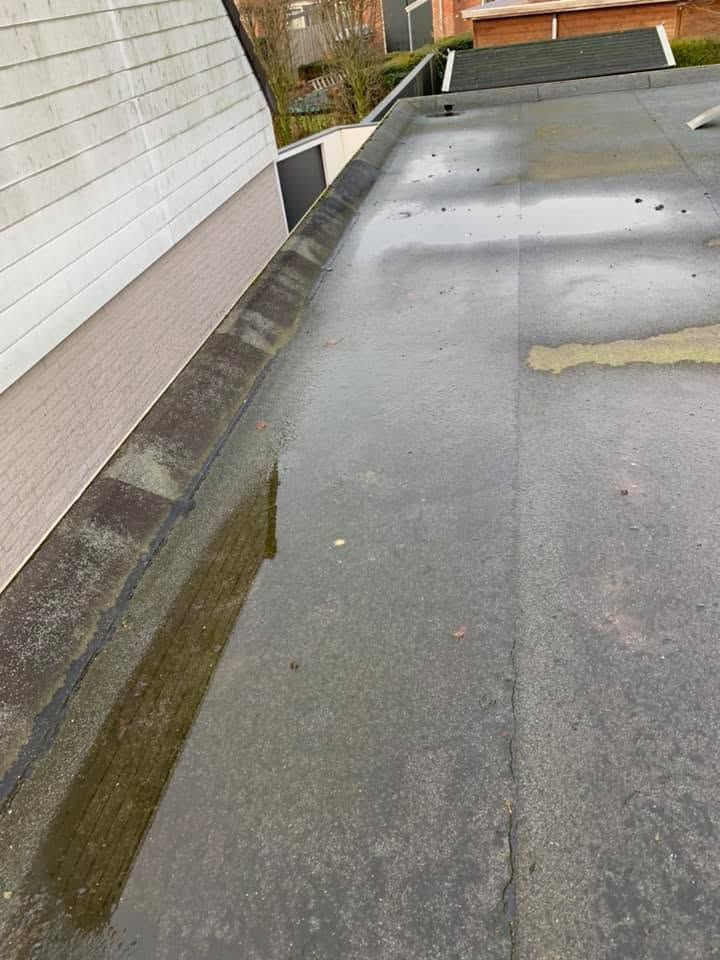 Plat dak voor het werk, met plassen water